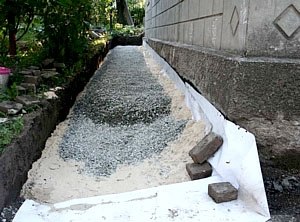 На гидроизоляцию укладывают слой щебня, глины и песка