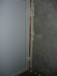 Вид на заделку монтажной пеной щели между стеной и обсадой двери