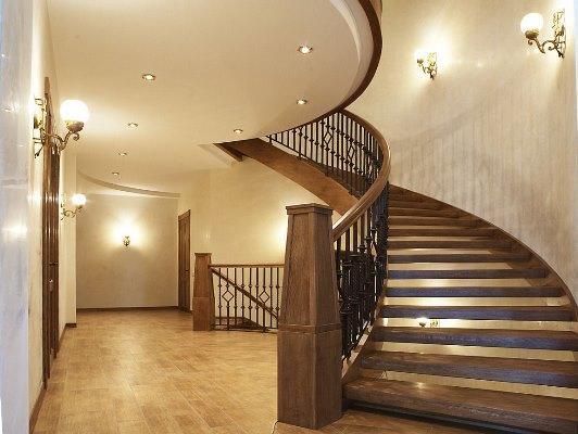 Красивая лестница с деревянными ступенями вполне может дополнить современный интерьер загородного дома