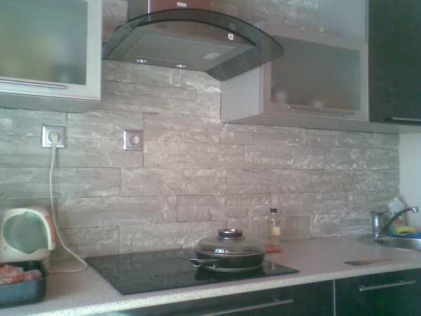 Стена в кухне облицована гипсовым камнем.