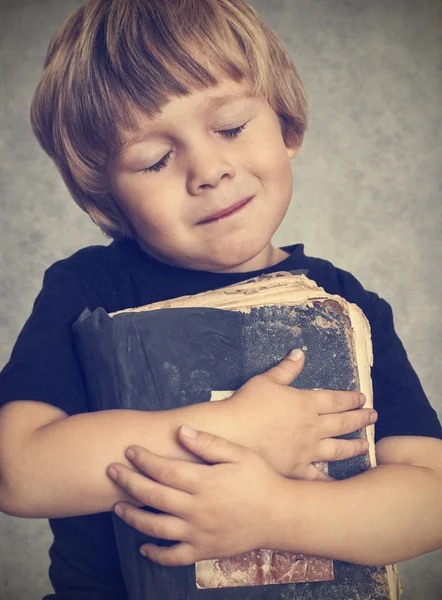 Маленький мальчик, обнимая старую книгу — стоковое фото