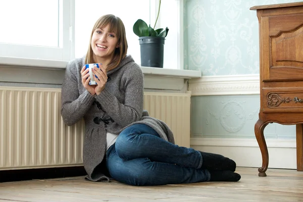 Счастливый молодая женщина, дома отдыха с чашкой чая — стоковое фото