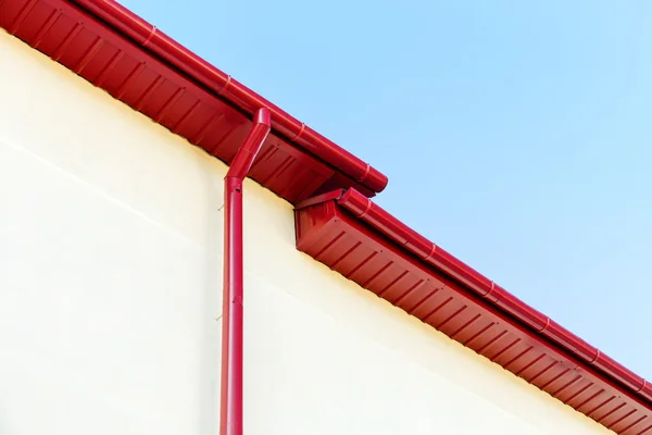 Красный дождь водосточные системы на крыше — стоковое фото