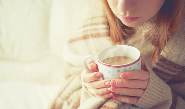 Чашка горячего кофе, нагревающегося в руках девочки — стоковое фото