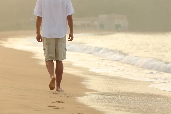 Человек, ходить и оставляя следы на песке пляжа. — стоковое фото