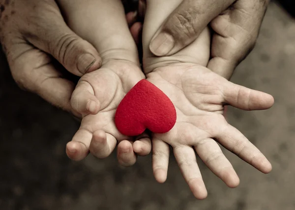 Рука ребенка с красным сердцем — стоковое фото