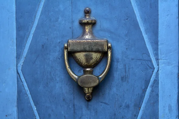 Старый doorknocker из латуни на синий двери — стоковое фото