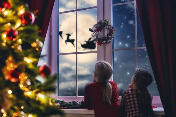 Девочки, сидя у окна и глядя на Санта — стоковое фото