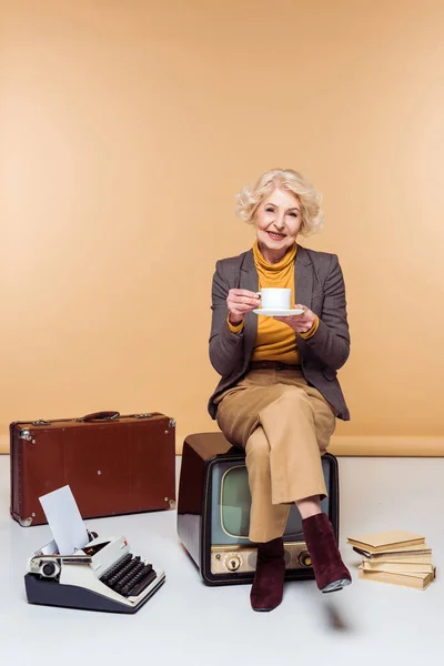 Стильные Старший Женщина Пить Кофе Сидя Ретро Вблизи Пишущая Машинка — стоковое фото