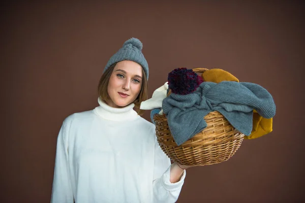 Женщина, держащая корзина с шапки и Шарфы — стоковое фото
