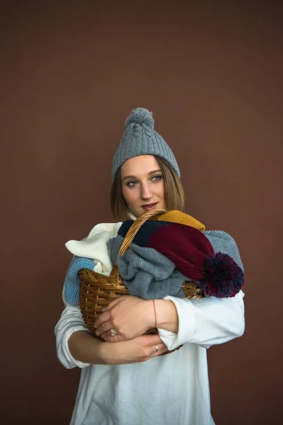 Женщина, держащая корзина с шапки и Шарфы — стоковое фото