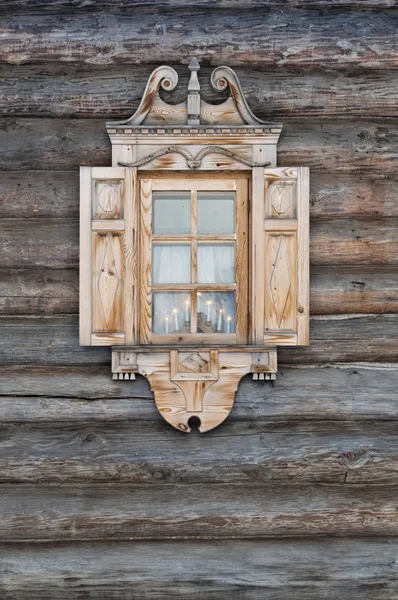 Окно с резными наличниками в деревянной хижине — стоковое фото