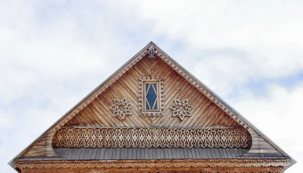 Резной фронтон деревянного дома против неба. — стоковое фото