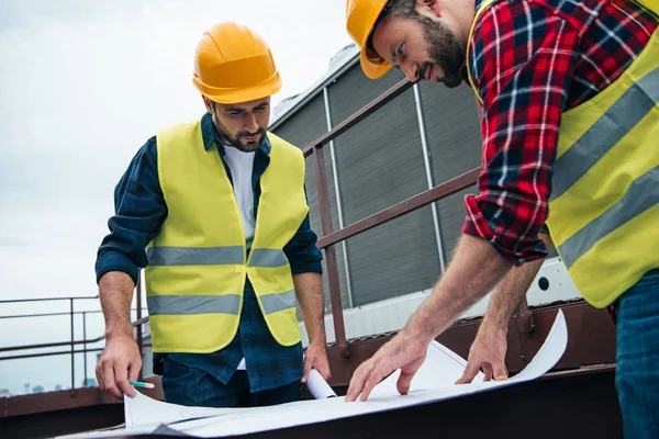 Architects Safety Vests Hardhats Working Blueprints Roof — стоковое фото